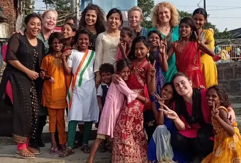 Foto di gruppo delle volontarie con le ragazze e i bambini del centro